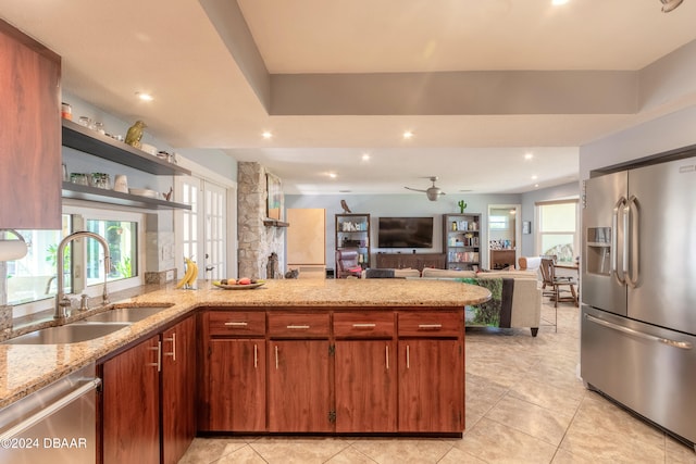 kitchen featuring light stone counters, light tile patterned flooring, appliances with stainless steel finishes, sink, and kitchen peninsula