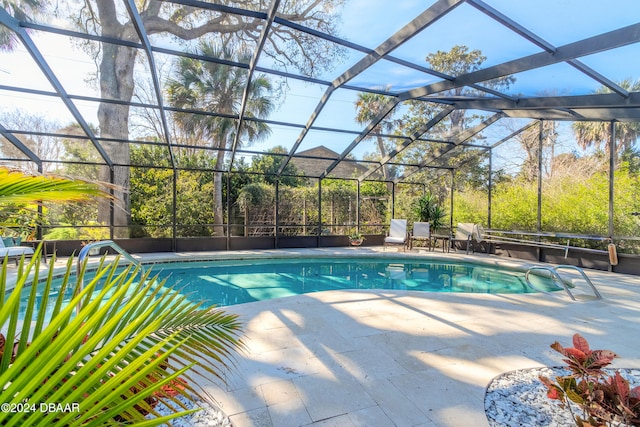 view of swimming pool featuring glass enclosure and a patio