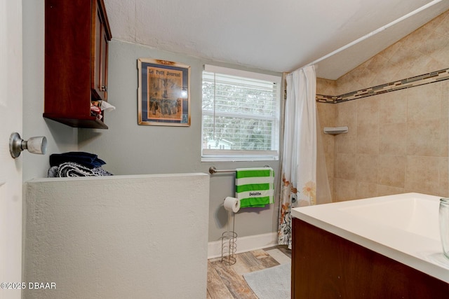 bathroom with vanity, hardwood / wood-style flooring, and walk in shower