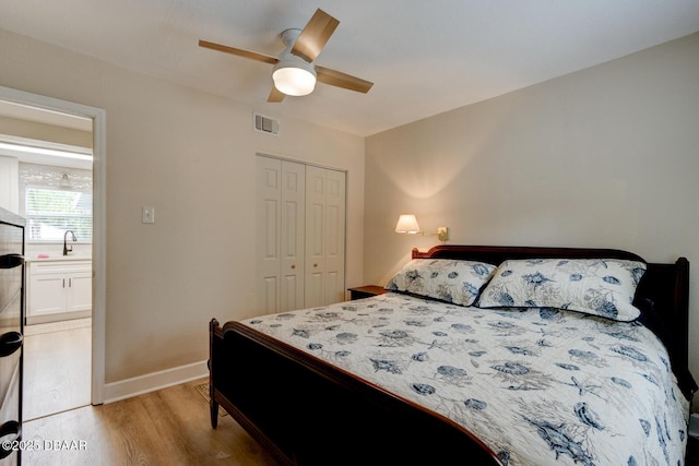 bedroom featuring a closet, sink, ceiling fan, and light hardwood / wood-style flooring