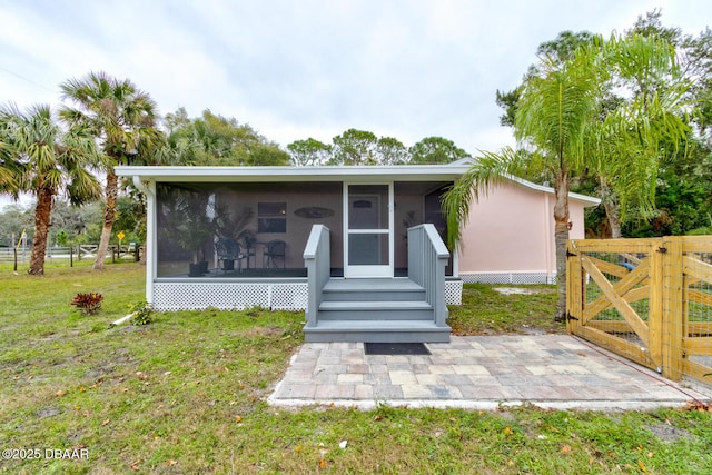 view of front of house featuring a sunroom and a front yard