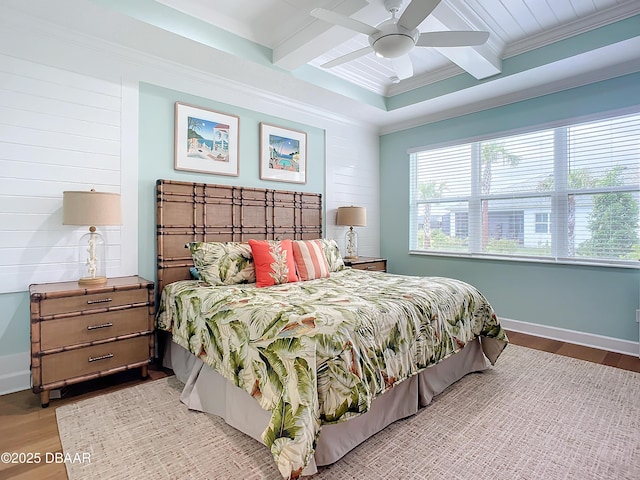 bedroom featuring light wood-type flooring, coffered ceiling, ceiling fan, crown molding, and beamed ceiling