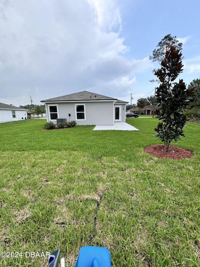 8 Phoenix Ln, Palm Coast, FL 32164 - back of house with a patio area, a lawn, and central AC unit