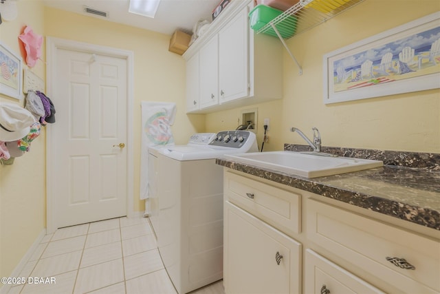 laundry area with sink, washing machine and dryer, cabinets, and light tile patterned flooring