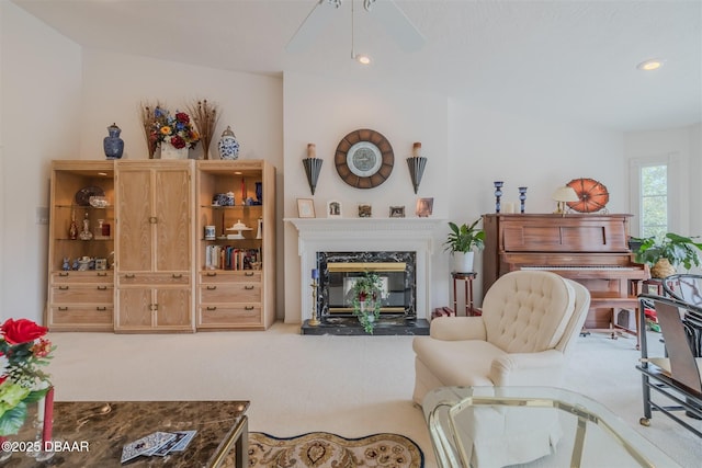 living room with ceiling fan, carpet floors, and a fireplace