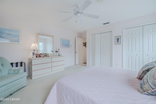 bedroom with ceiling fan and multiple closets