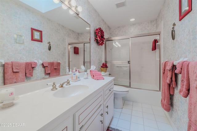 full bathroom with enclosed tub / shower combo, a skylight, vanity, tile patterned floors, and toilet