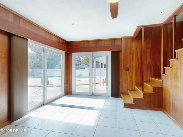 interior space with light tile patterned floors and wood walls