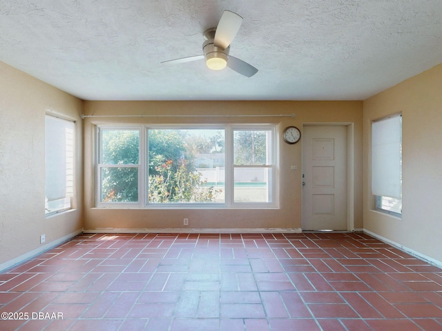 interior space featuring ceiling fan and a textured ceiling