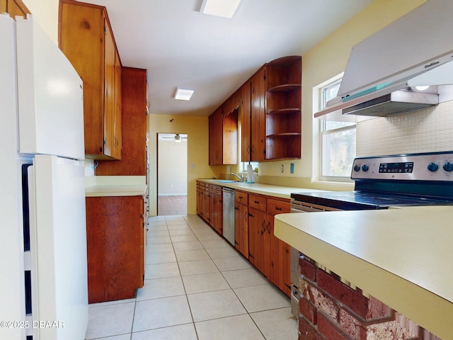 kitchen with sink, extractor fan, tasteful backsplash, light tile patterned floors, and stainless steel appliances