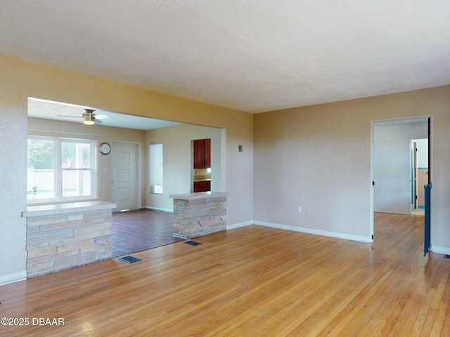 unfurnished living room with ceiling fan and light wood-type flooring