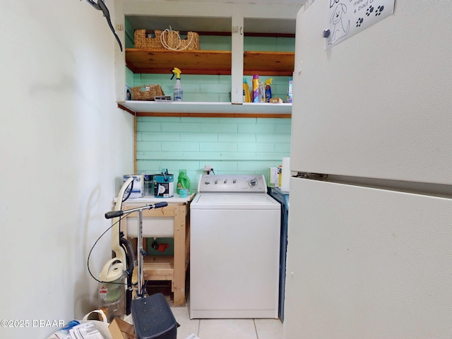 laundry room featuring washer / clothes dryer and light tile patterned floors