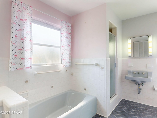 bathroom featuring shower with separate bathtub, tile walls, and tile patterned floors