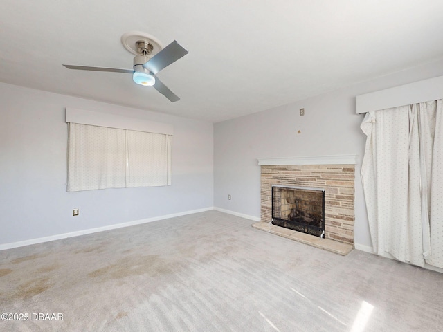 unfurnished living room with ceiling fan, light colored carpet, and a stone fireplace