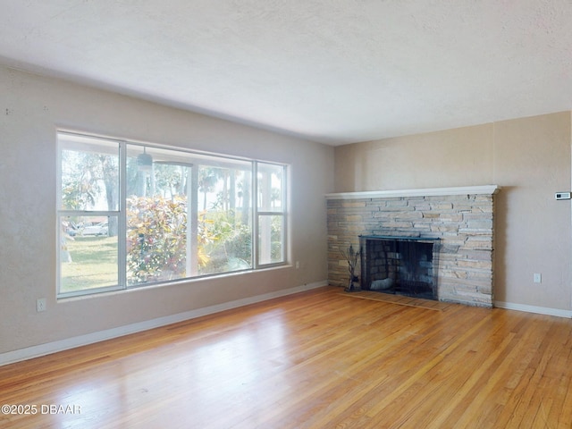 unfurnished living room featuring a fireplace and light hardwood / wood-style floors