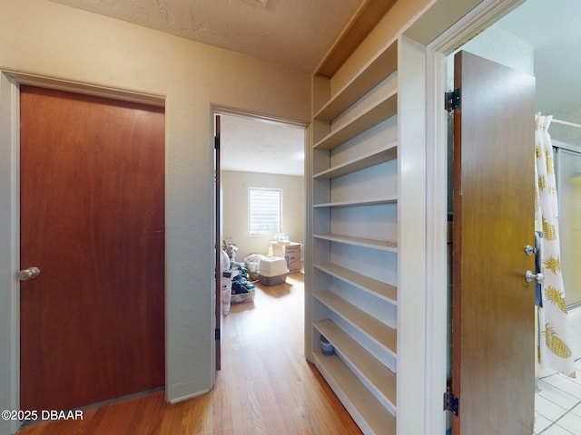 hallway featuring light hardwood / wood-style flooring and built in features