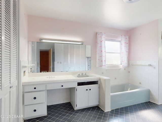 bathroom featuring tile patterned flooring, vanity, a bathing tub, and tile walls