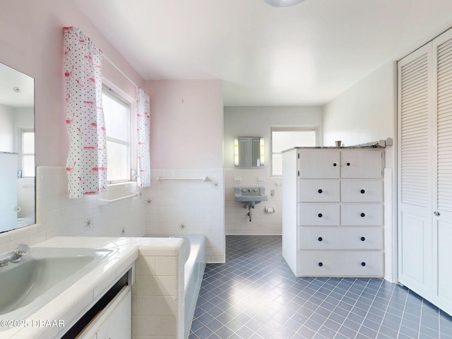 bathroom featuring tile walls, sink, a washtub, and tile patterned floors