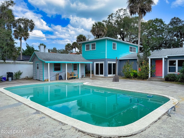 view of swimming pool featuring an outbuilding and a patio area