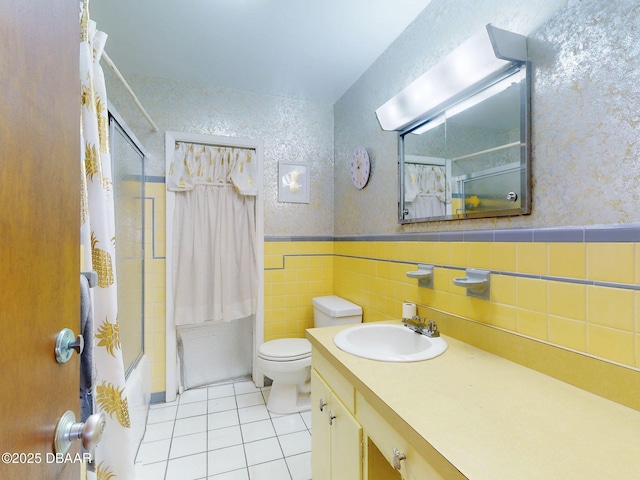 full bathroom featuring shower / tub combo with curtain, toilet, tile walls, vanity, and tile patterned flooring