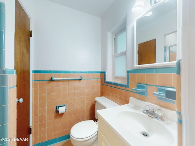 bathroom featuring vanity, tile walls, and toilet