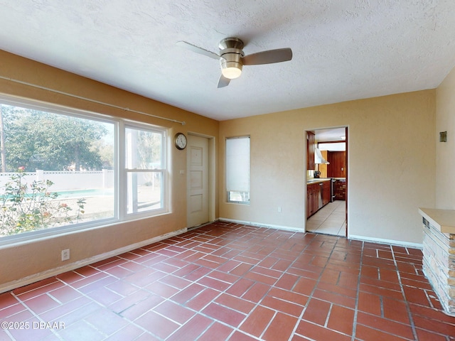 spare room with a textured ceiling and ceiling fan