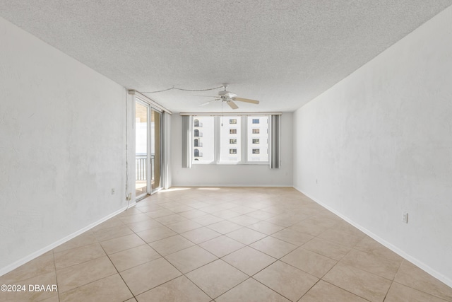 tiled empty room featuring a textured ceiling and ceiling fan