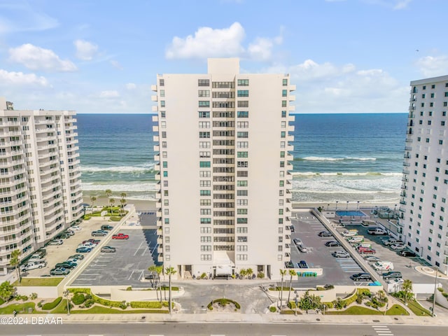 view of building exterior featuring a beach view and a water view