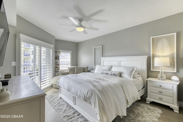 bedroom featuring dark hardwood / wood-style flooring, a textured ceiling, and ceiling fan