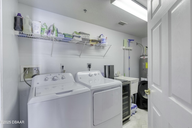 clothes washing area with washing machine and clothes dryer, sink, and electric water heater