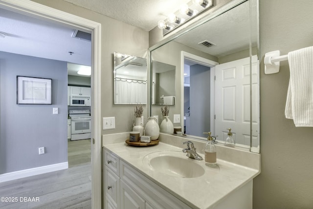 bathroom featuring vanity, hardwood / wood-style flooring, and a textured ceiling