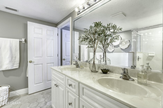 bathroom featuring walk in shower, tile patterned floors, a textured ceiling, and vanity