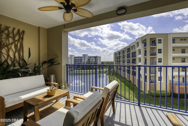 balcony featuring outdoor lounge area, ceiling fan, and a water view