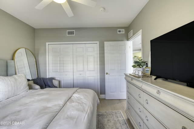 bedroom featuring ceiling fan, light hardwood / wood-style floors, and a closet