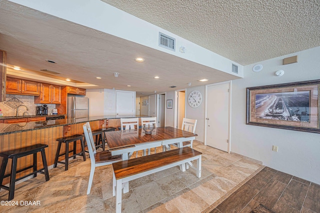 dining room with a textured ceiling and sink