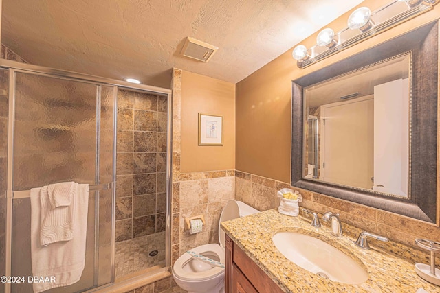 bathroom with toilet, vanity, a textured ceiling, and walk in shower