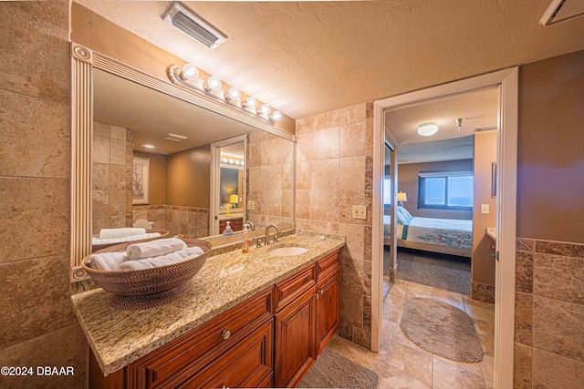 bathroom featuring vanity, tile walls, and a textured ceiling