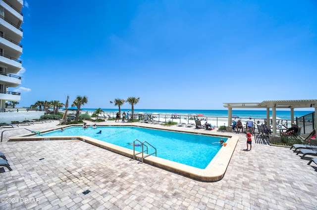 view of swimming pool featuring a water view and a patio