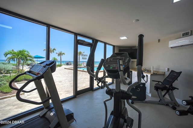 exercise room with an AC wall unit, expansive windows, and a healthy amount of sunlight