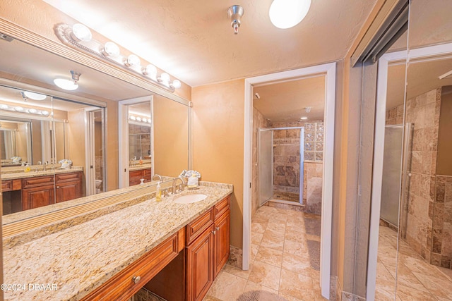 bathroom with vanity, a textured ceiling, and a shower with door