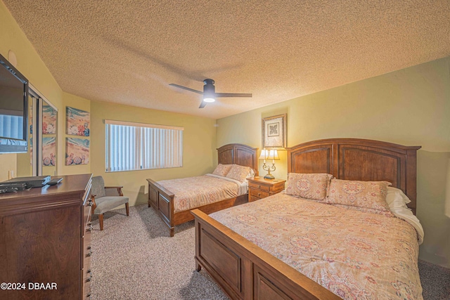 carpeted bedroom with ceiling fan and a textured ceiling