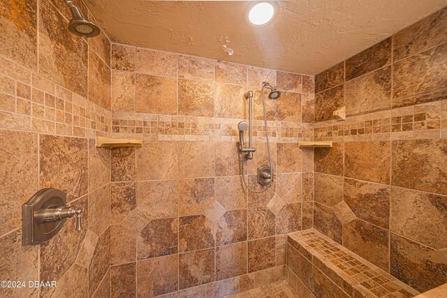 room details with a textured ceiling and tiled shower