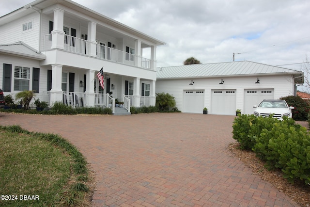 view of front of home featuring a balcony, covered porch, and a garage