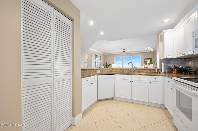 kitchen featuring sink, ceiling fan, white appliances, white cabinets, and decorative backsplash