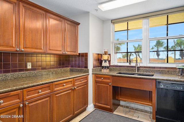 kitchen featuring dishwasher, decorative backsplash, light tile patterned floors, sink, and dark stone countertops