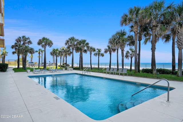 view of pool featuring a water view and a patio area