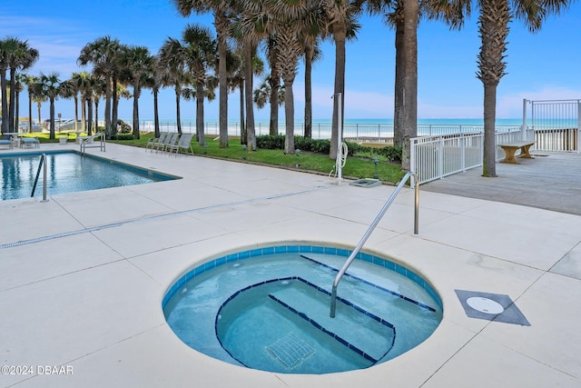 view of swimming pool with a patio area, a water view, and a community hot tub