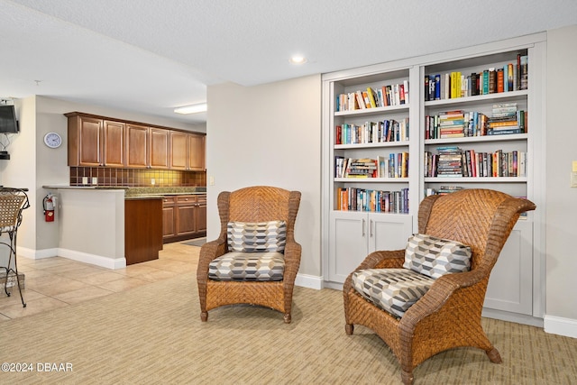 living area with a textured ceiling and light tile patterned floors