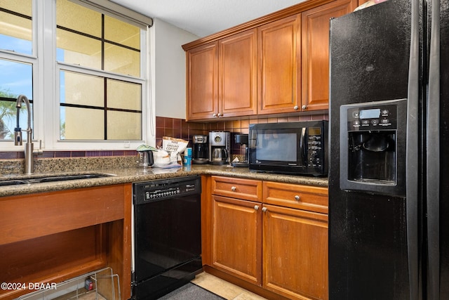 kitchen featuring black appliances, backsplash, and sink