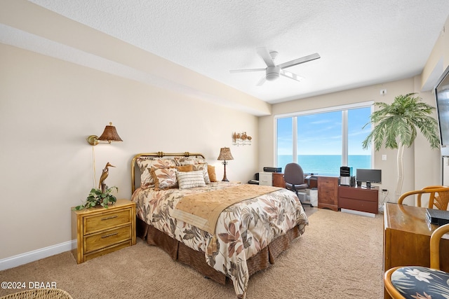 bedroom featuring a textured ceiling, ceiling fan, and carpet floors